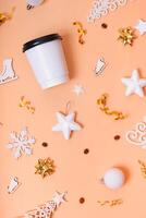 Mockup of coffee cardboard cup with Christmas decorations flat lay, top view on trendy 2024 Peach Fuzz color background photo