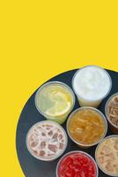 Takeaway glasses of summer drinks with ice. Lemonades and coctails on the table photo