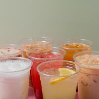 Lemonades and coctails on coloured background. Takeaway glasses of summer drinks with ice photo