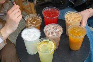 dos personas y comida rápida lentes de verano bebidas con hielo en el mesa. limonadas y cocteles foto