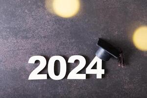 Wooden number 2024 with graduated cap. Class of 2024 concept. photo