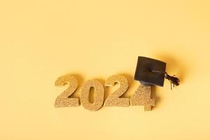 Golden glitter number 2024 with graduated cap. Class of 2024 concept. photo