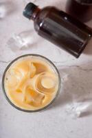 Cold brew coffee with milk and ice and cold brew coffee in bottles top view. photo