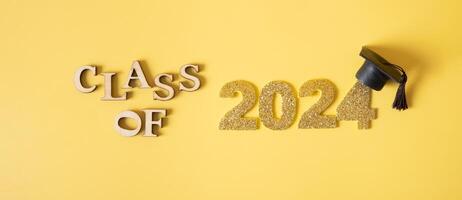 Class of 2024 concept. Number 2024 with graduated cap on yellow background photo