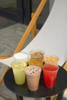 Takeaway glasses of summer drinks with ice. Lemonades and coctails on the table photo