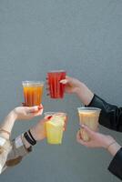 Takeaway glasses of summer drinks with ice in woman's hands. Copy space photo