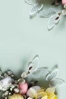 Butterflies and flowers, easter eggs and willow on green background with copy space. Easter greeting card template photo