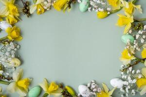 Spring flowers ans easter eggs border on green background with copy space. Easter greeting card template photo