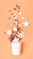 Mockup of coffee cardboard cup with Christmas decorations flat lay, top view on trendy 2024 Peach Fuzz color background photo