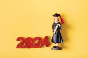 Class of 2024 concept. Number 2024 with statuette in graduation cap and gown photo