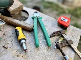 Desk of a carpenter with different tools on a wooden background. photo