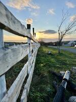 cercado rancho a atardecer, la carretera a granja, vertical foto