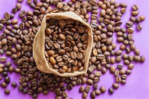 coffee beans in a burlap bag on the purple background,place for inscription photo