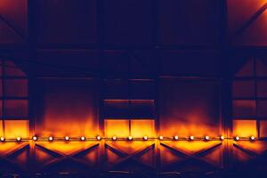 Dark draped decorated wall with red orange backlight photo