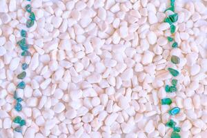 A scattering of pink stones, pebbles, two emerald stone stripes photo