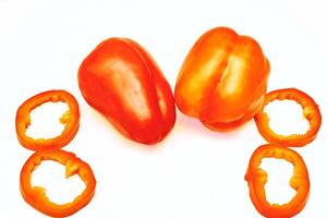 Red sweet ripe pepper cut into circles,slices on white photo