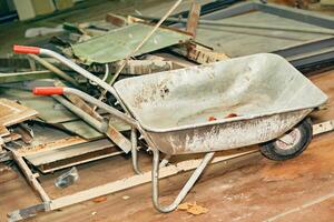 Construction metal wheelbarrow, various waste after repair photo