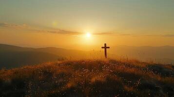 Silhouette of a cross on a hill in a mountain landscape at sunset. photo