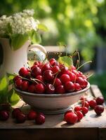 Fresh red cherries fruit in bowl on table in garden photo