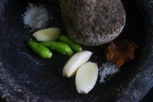 cerca arriba de un cocina herramienta en el formar de un Roca licuadora llamado cobek foto