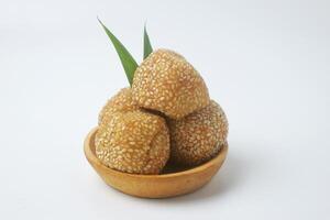 A close up shot of a snack that has a golden round shape is often called Onde Onde photo