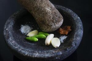 Close up of a stone blender is for making green chilli sauce photo