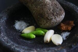 Close up of a stone blender is for making green chilli sauce photo