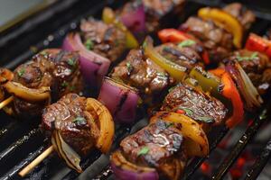 Skewers of meat on the grill with onions and peppers. photo