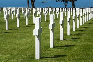 americano cementerio a Normandía área. tumba con azul Oceano en primer plano a segunda Guerra Mundial monumento. foto