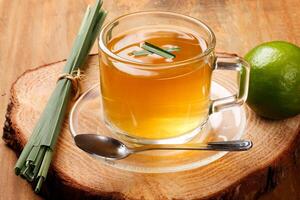 lemongrass tea in glass cup on rustic tree trunk table photo