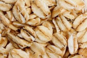 macro photography of a portion of Raw organic oat flakes covering the entire background. image for packaging photo