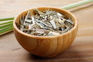 portion of dried organic lemongrass on rustic wooden table photo