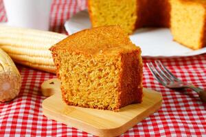 rebanada hecho en casa maíz pastel en de madera mesa. típico brasileño fiesta alimento. foto