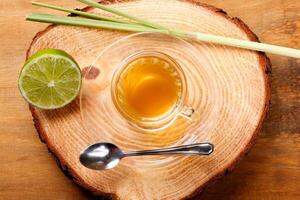 lemongrass tea in glass cup on rustic tree trunk table photo