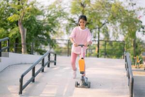 A young girl riding a scooter down a ramp photo