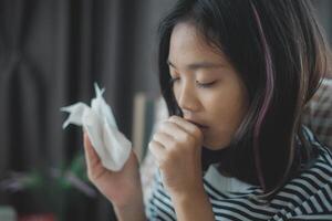 A girl is holding a tissue and coughing photo