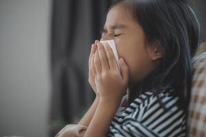 enfermo asiático muchachas tener alto fiebres y gripe y estornudar dentro tejidos en cama en el dormitorio, cuidado de la salud y evitar el untado de infección virus concepto, foto