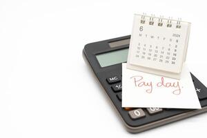 Hand writing text PAY DAY on June 2024 calendar with calculator in isolated background. Reminder concept of payment. copy space. photo