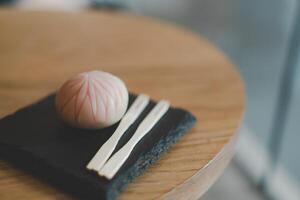 nerikiri wagashi japonés dulce en de madera mesa. japonés pequeño bonito dulces vistoso. foto