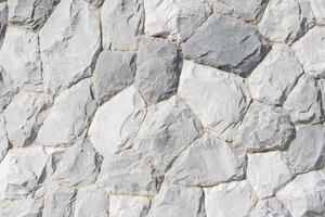 Full frame of natural stone wall. Rock background texture, wall background, stone, abstract. A beautiful stone wall constructed from grey stones. photo