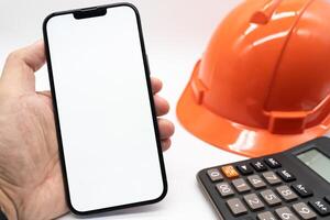 Engineer's Hand Holding smartphone with Blank Screen. Copy space on cellphone screen. engineer working on his smartphone. photo