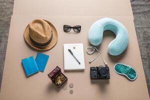 Packed suitcase of vacation items on wooden table, top view photo