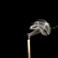 Wooden match burning on a black background photo