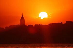 Galata Tower view at sunset with sun behind the clouds photo