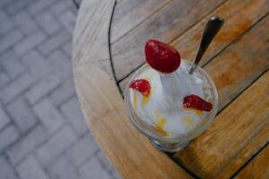 Top view of Vanilla ice cream in bowl with raspberry on wooden table. photo