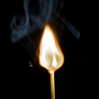 Wooden match burning on a black background photo