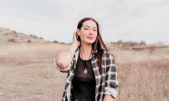 contento joven sonriente mujer con pecas al aire libre retrato. suave soleado colores. al aire libre de cerca retrato de un joven morena mujer y mirando a el cámara, posando en contra otoño naturaleza antecedentes foto