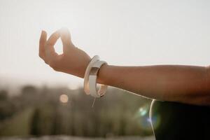 aptitud mujer. bien mirando medio Envejecido mujer con largo cabello, aptitud instructor en polainas y tapas haciendo extensión y pilates en el rock cerca bosque. hembra aptitud yoga rutina concepto. foto