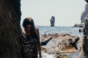 Woman summer travel sea. Happy tourist enjoy taking picture outdoors for memories. Woman traveler posing on the beach at sea surrounded by volcanic mountains, sharing travel adventure journey photo