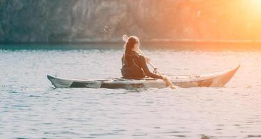 mujer mar kayac. contento sonriente mujer en kayac en océano, remar con de madera remo. calma mar agua y horizonte en antecedentes. activo estilo de vida a mar. verano vacaciones. foto